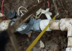 irrigation contractor in North Miami, FL removes a pvc pipe from a sprinkler valve with a hacksaw