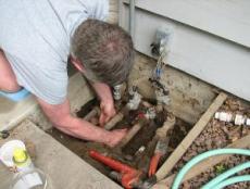 mark performs a maintenance check on a sprinkler valve